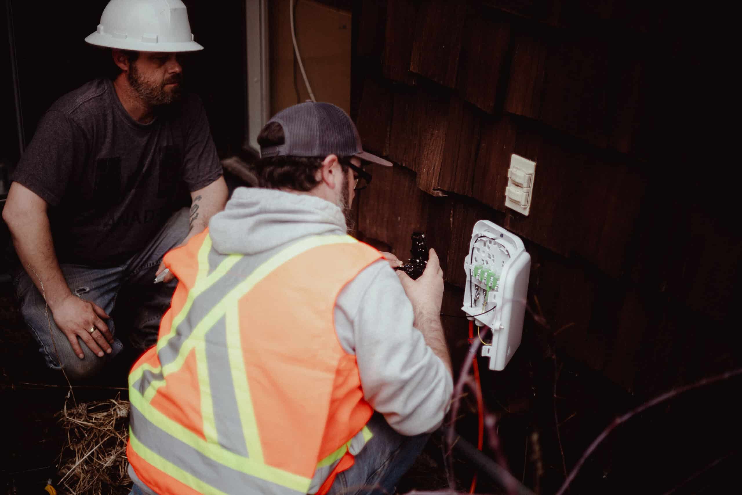 An internet technician is installing a fiber optic connection by opening a fiber optic connector.