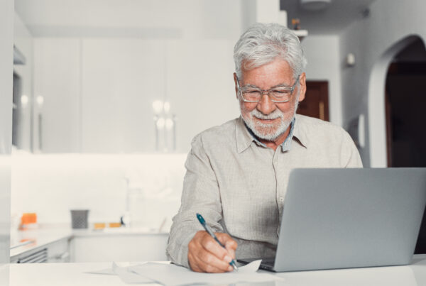 Concentrated senior male in glasses work on laptop from home office