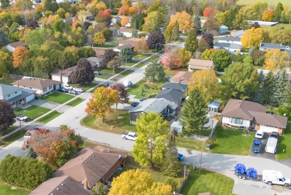 Aerial view of a rural neighborhood with scattered houses, tree-lined properties, and long driveways connecting homes to the road.