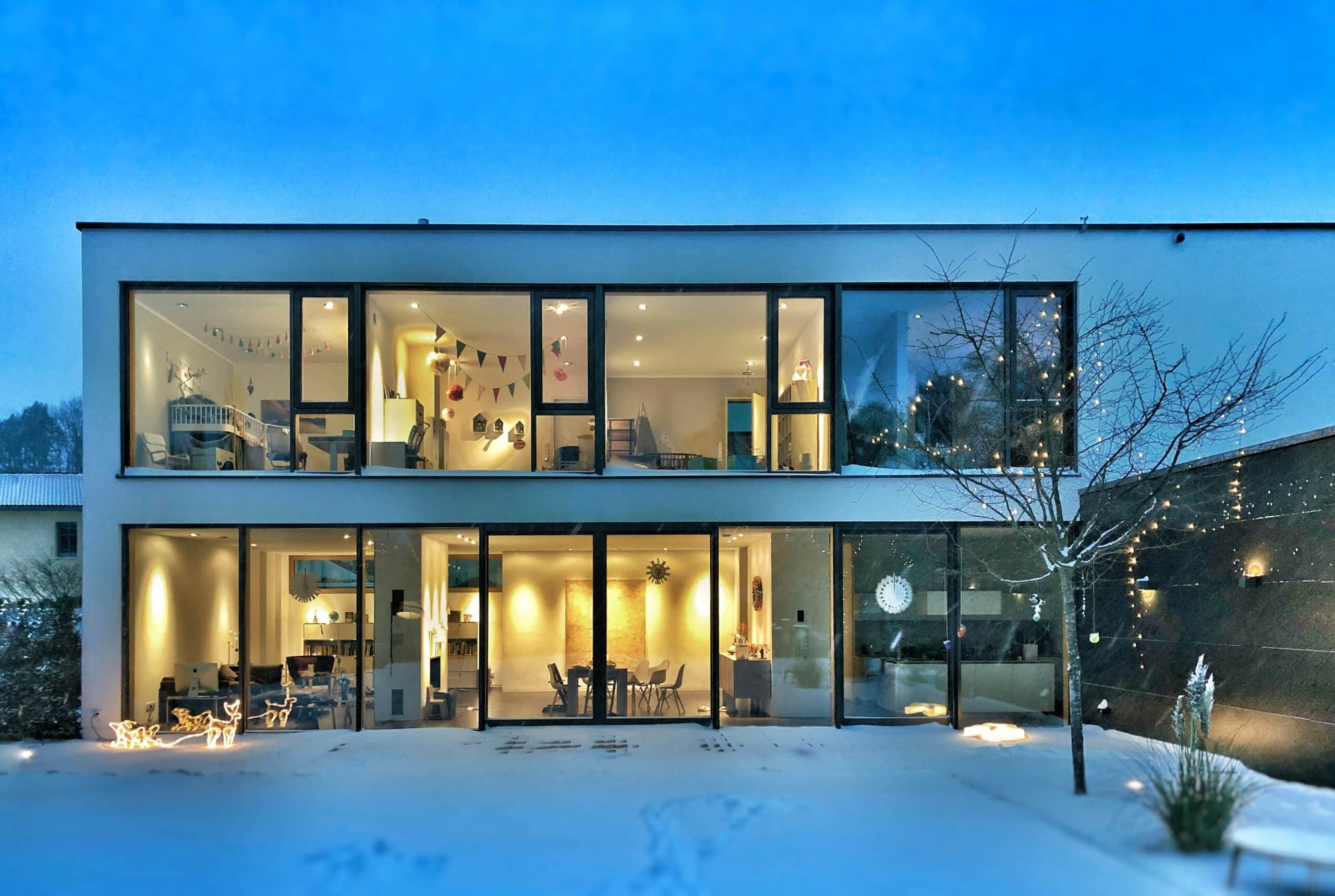 Modern smart home with illuminated interior and large glass windows