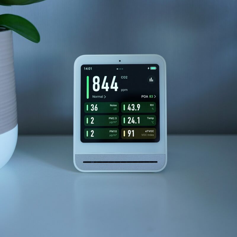 Smart home clock device displaying time and temperature on a desk