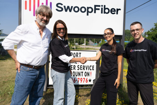 execteam+township SwoopFiber executives shaking hands with local officials during a meeting.