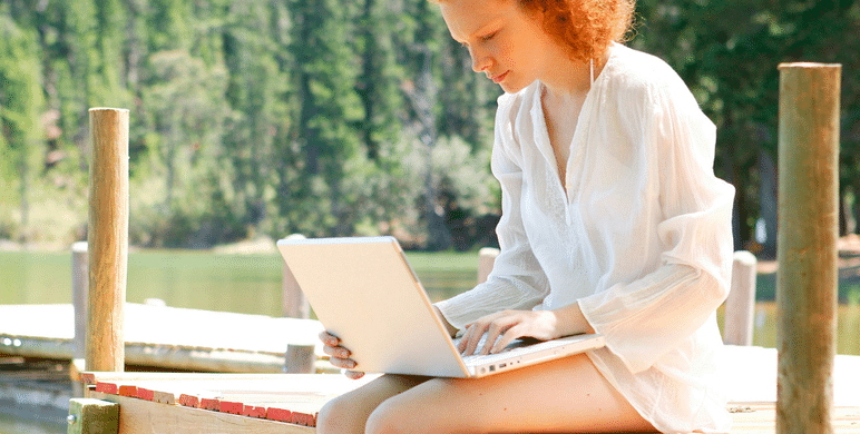 Woman using her laptop on dock