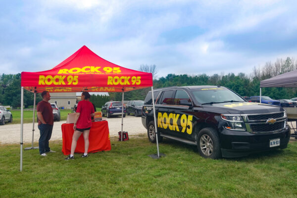 023 Rock 95 Tent and car parked on the grass at SwoopFiber storefront