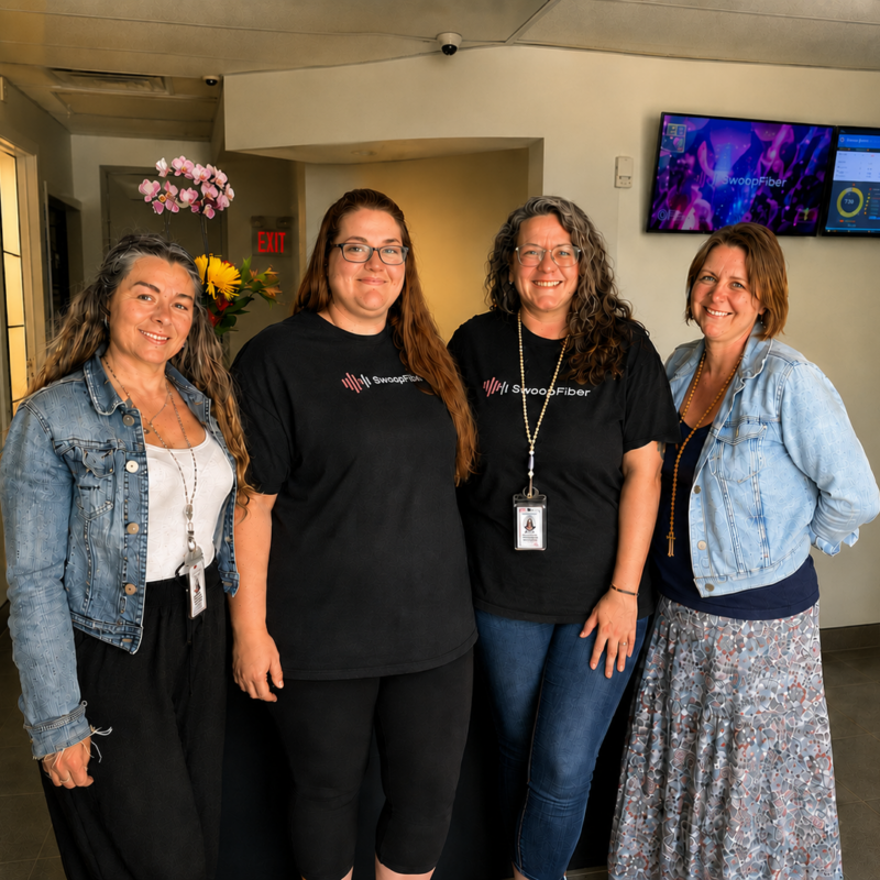 Four SwoopFiber Staff memebers standing in the storefront smiling