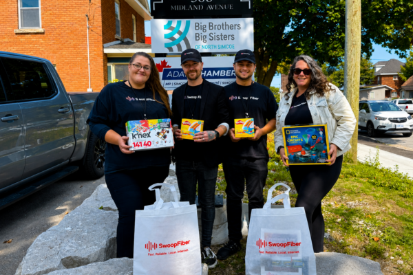 ChatGPT Image May 14, 2026, 08_01_19 PM SwoopFiber team members holding donation gifts outside Big Brothers and Big Sisters in Elmvale
